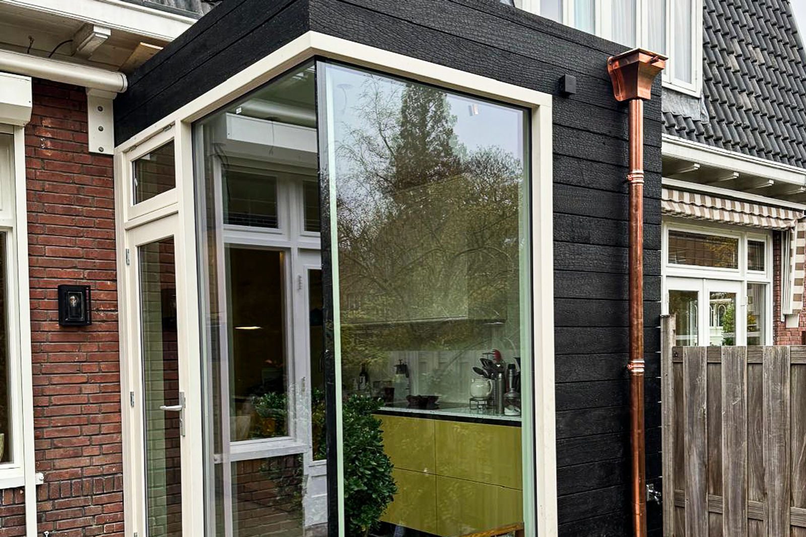 Black charred timber extension next to brickwork